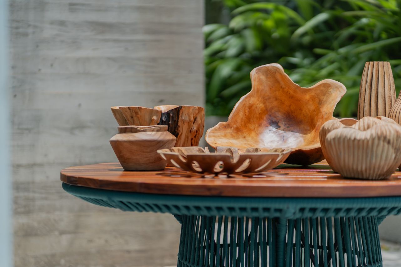 A collection of wooden bowls and vases on a rustic table, featuring natural decor and organic design elements.