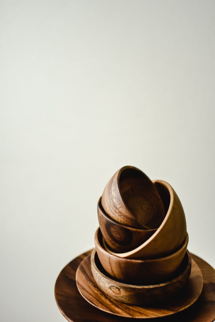 Minimalist image of stacked handcrafted wooden bowls on a wooden plate, perfect for modern decor concepts.