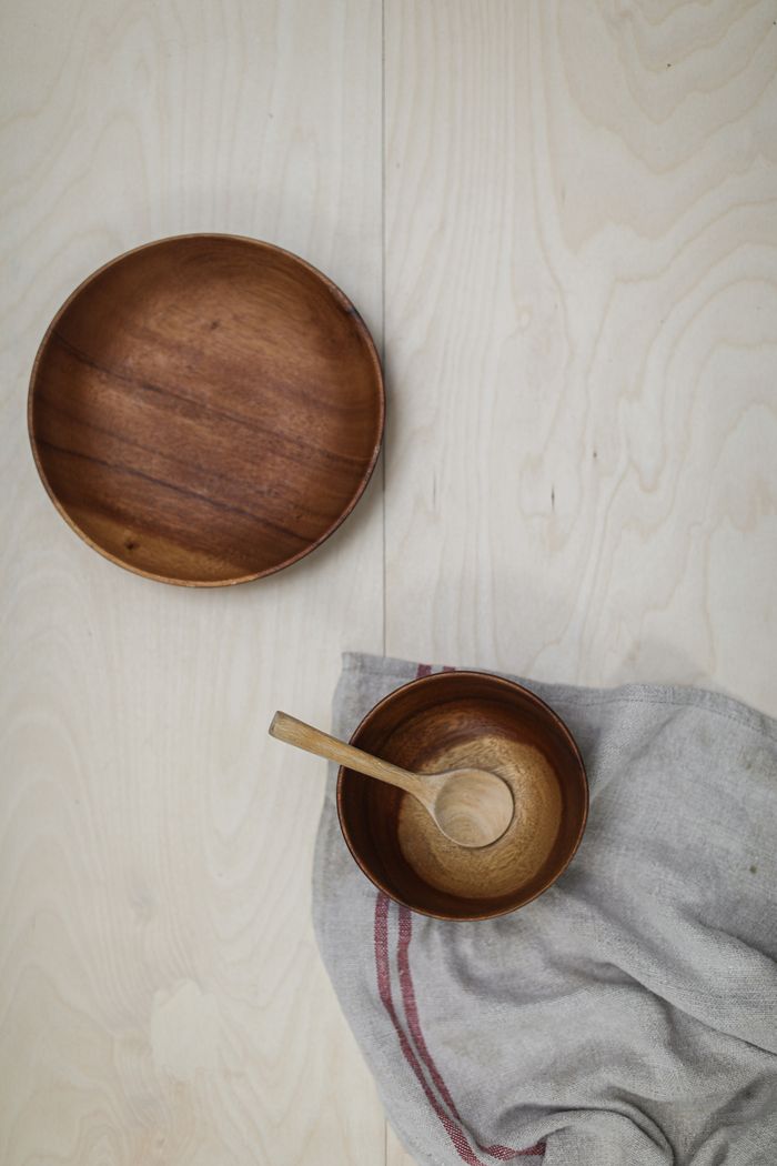 Top view of wooden bowls and spoon on a linen cloth, minimalist design.