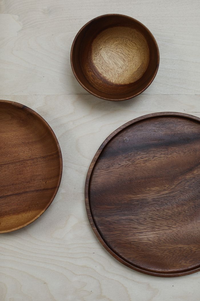 Top view of three wooden plates and bowls on a light flat surface. Perfect for minimalist decor.