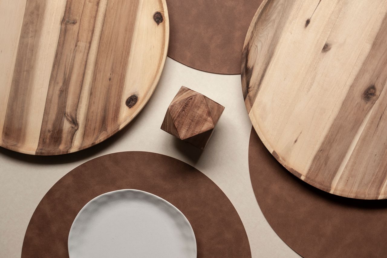 Stylish arrangement of wooden plates and a geometric wooden block with earthy tones, creating a minimalistic aesthetic.